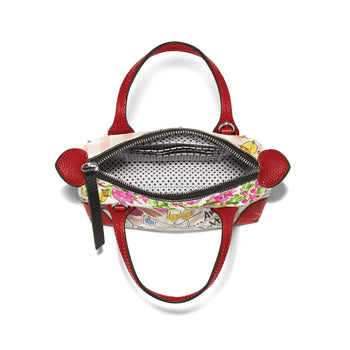 Brighton handbag shown open with polka dot interior, red leather handles, and floral print exterior on a white background