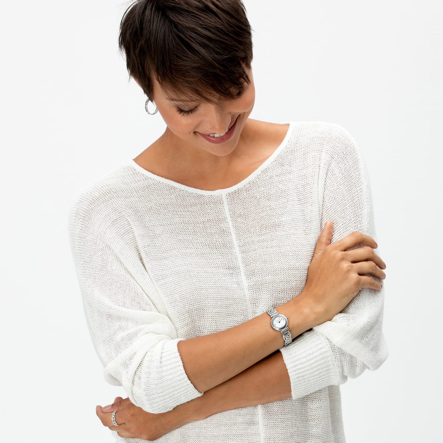 Model wearing a Brighton watch with round silver-tone dial and decorative scroll-detailed bracelet band