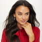Model wearing Brighton silver-plated drop earrings with cat charms holding candy canes, paired with silver-plated stacked rings