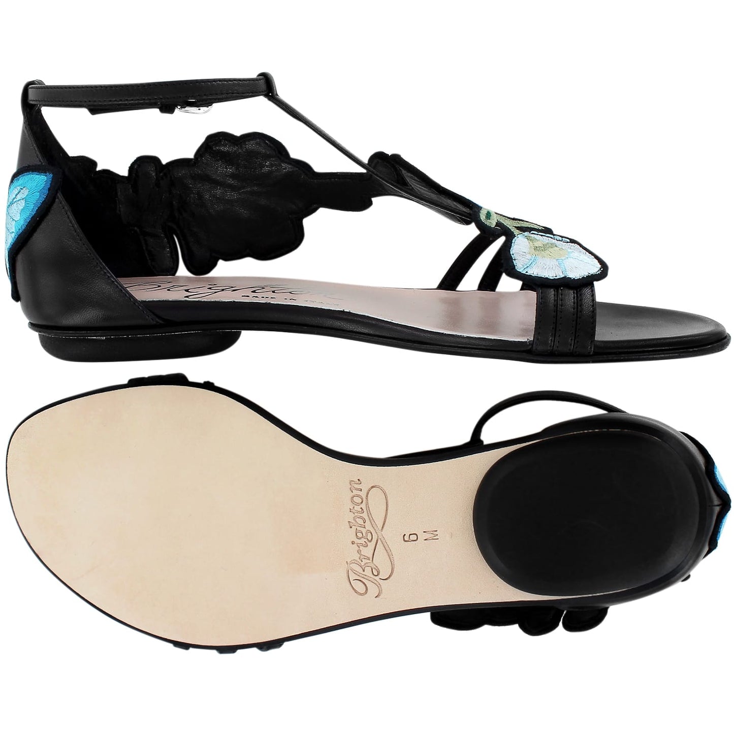 Brighton flat sandals in black leather with blue floral embroidery and T-strap design, sole view shown, on a white background