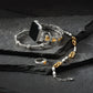 Silver and gold Brighton bracelet with heart charms on a dark stone surface