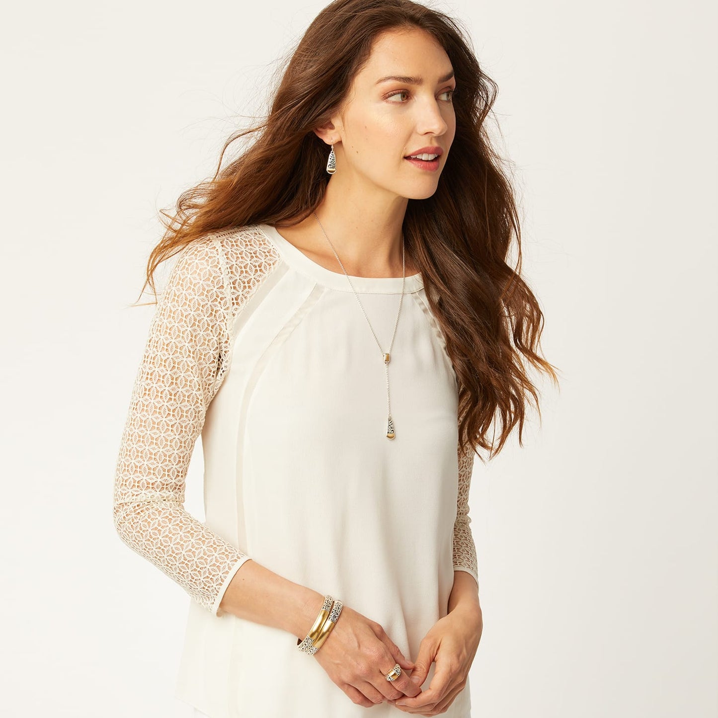 Model wearing a Brighton silver-plated lariat necklace with gold-plated drop pendant and coordinating Brighton accessories
