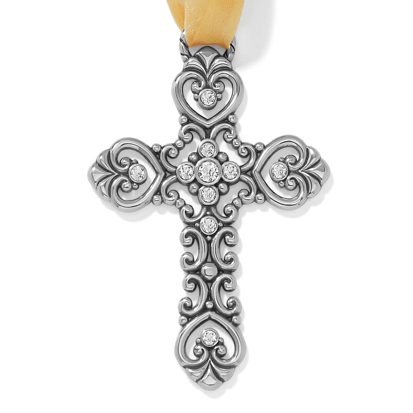 Brighton silver-plated cross pendant with ornate scrollwork, heart motifs, crystal accents, and yellow ribbon on a white background