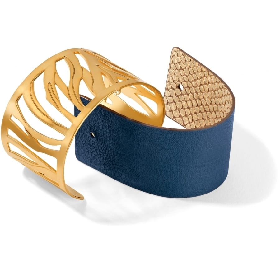Brighton cuff bracelet with gold-plated cutout design, navy leather band, and textured gold end cap on a white background