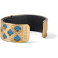 Brighton cuff bracelet with gold-plated quatrefoil openwork design, turquoise accents, and black leather interior on a white background