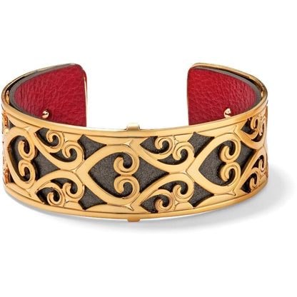 Brighton cuff bracelet with gold-plated scroll openwork over red leather interior lining on a white background