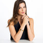 Model wearing a Brighton gold-plated bangle bracelet with circular openwork design and inset stone accents