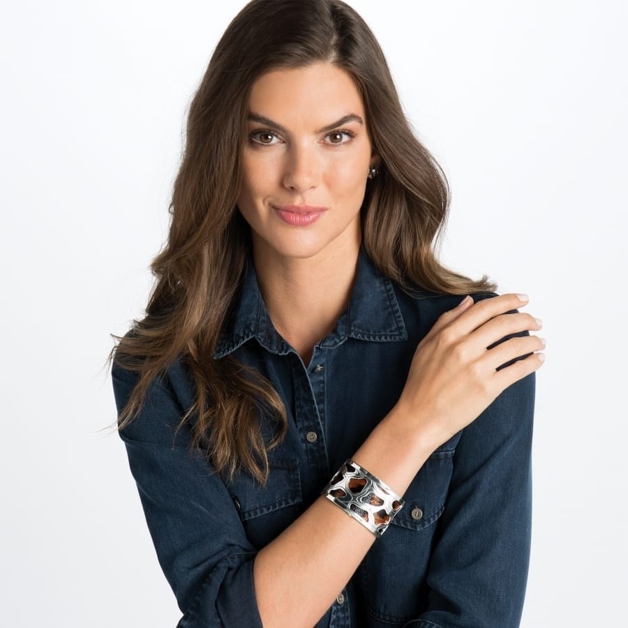 Model wearing a Brighton silver-plated cuff bracelet with animal print inlay and openwork silver-plated design