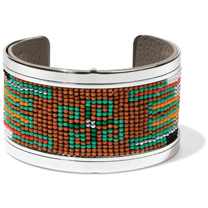 Brighton cuff bracelet with green, orange, and brown beaded geometric pattern and silver-tone frame on a white background