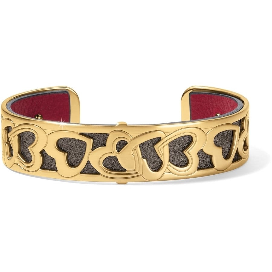 Brighton cuff bracelet with gold-plated interlocking heart design and red leather interior lining on a white background