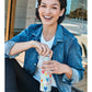 Model with a Brighton stainless steel water bottle featuring colorful heart print and light blue background