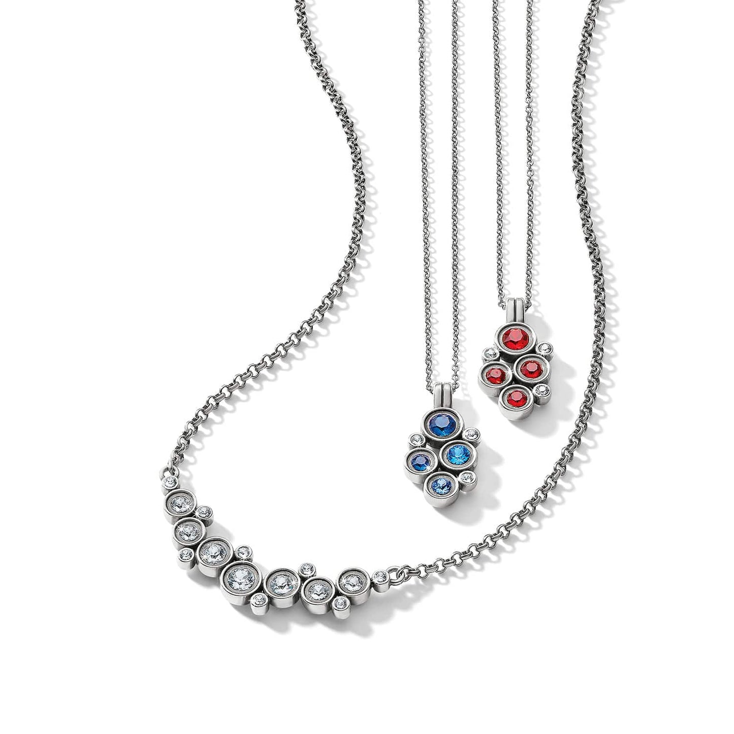 Brighton silver-plated necklaces with clustered clear, blue, and red crystal pendants on a white background