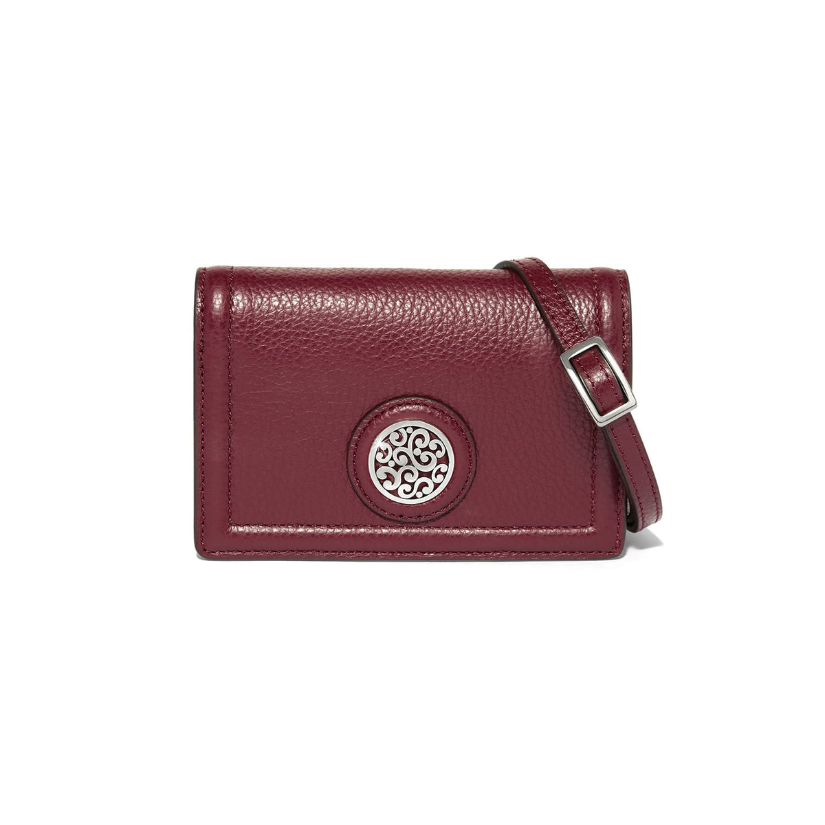 Brighton burgundy leather crossbody handbag with silver-tone medallion emblem and adjustable strap on a white background