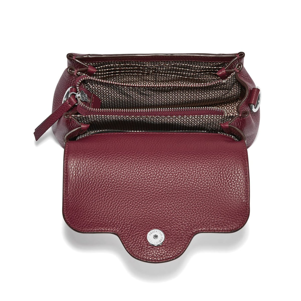 Brighton burgundy leather handbag shown open with patterned fabric interior and silver-tone snap closure on a white background
