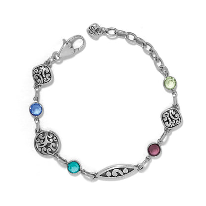Brighton silver-plated bracelet with crystals in blue, green, purple, and turquoise and scroll filigree stations on a white background