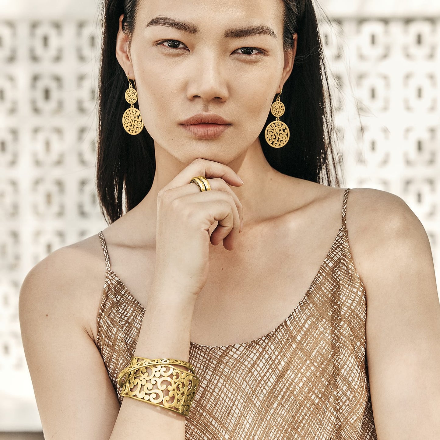 Model wearing Brighton gold-tone filigree drop earrings with coordinating Brighton stacked rings and openwork cuff bracelet