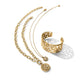 Brighton gold-plated jewelry set styled with a scroll-pattern cuff bracelet and matching pendant necklaces on white