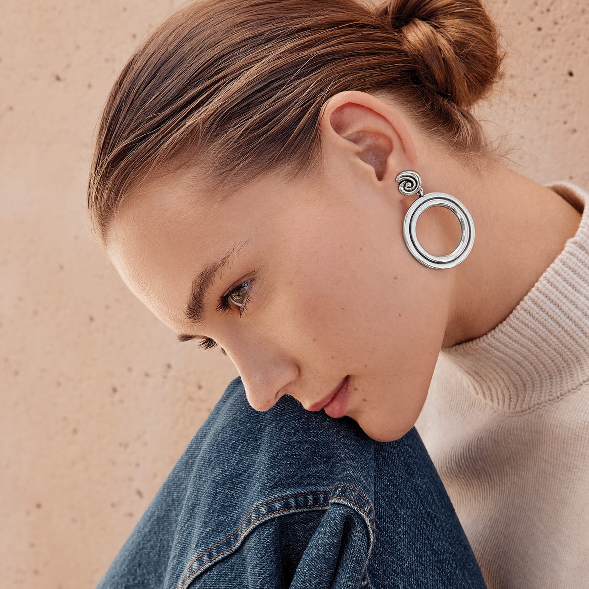 Model wearing Brighton silver-plated drop earrings with open circle design and spiral swirl post detail