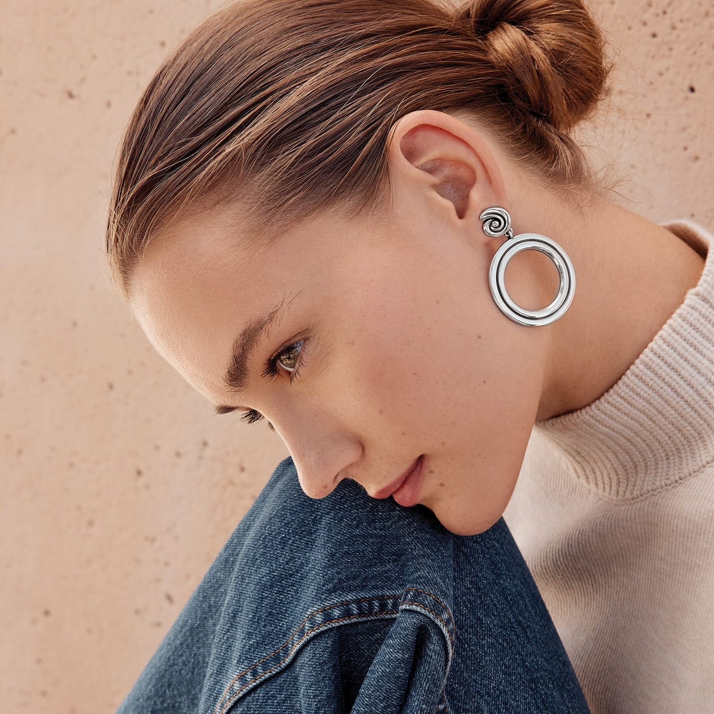 Model wearing Brighton silver-plated drop earrings with open circle design and spiral swirl post detail