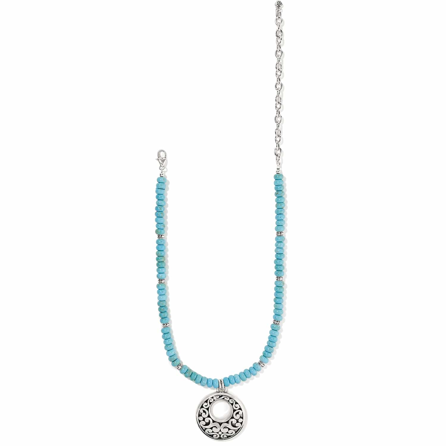 Brighton beaded necklace with turquoise dyed howlite beads, silver-plated scroll pendant, and chain on a white background