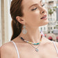 Model wearing Brighton silver-plated scroll drop earrings with coordinating Brighton beaded necklace and heart pendant necklace