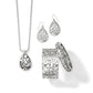Brighton jewelry set styled with silver-plated teardrop pendant necklace, matching earrings, and scrollwork bangle and cuff bracelets