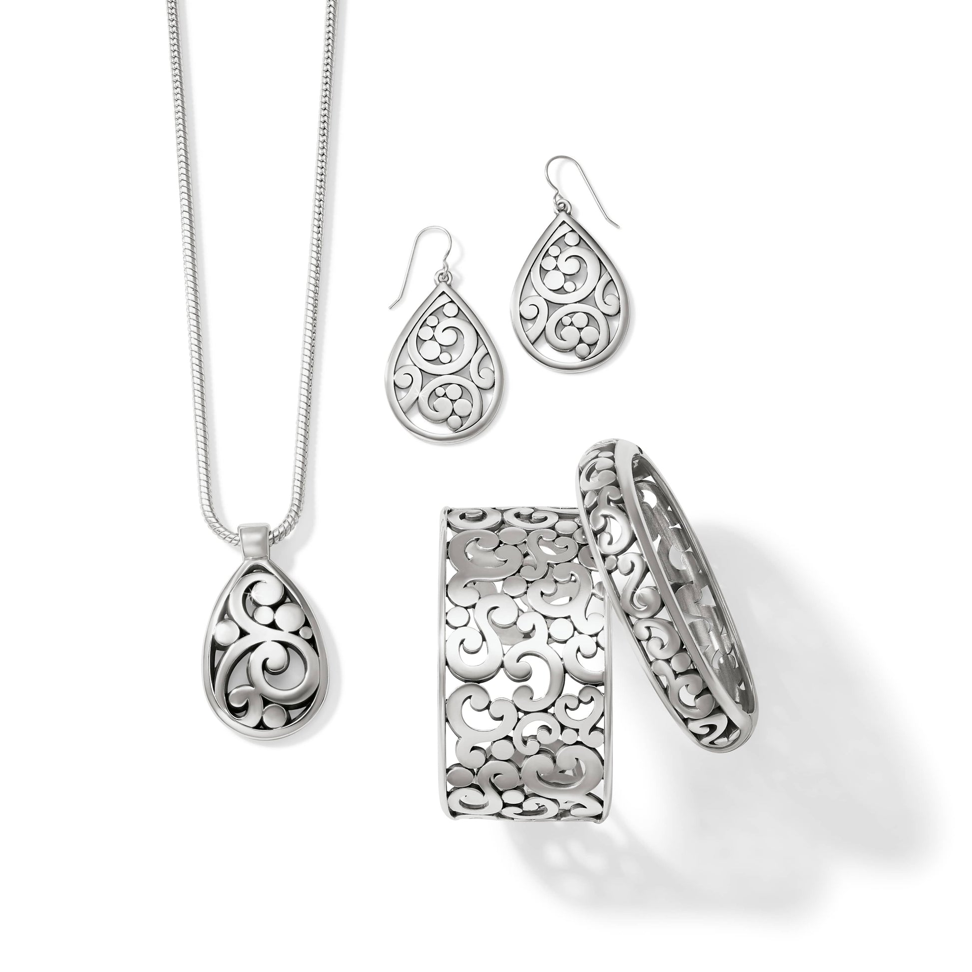 Brighton jewelry set styled with silver-plated teardrop pendant necklace, matching earrings, and scrollwork bangle and cuff bracelets