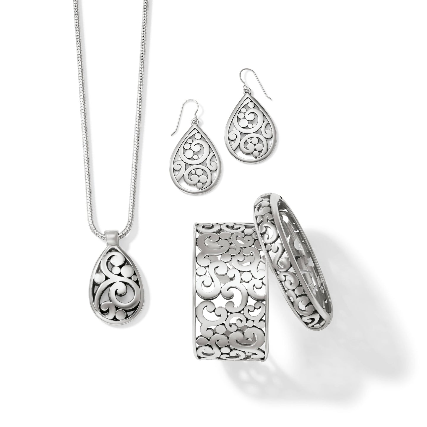 Brighton jewelry set styled with silver-plated teardrop pendant necklace, matching earrings, and scrollwork bangle and cuff bracelets