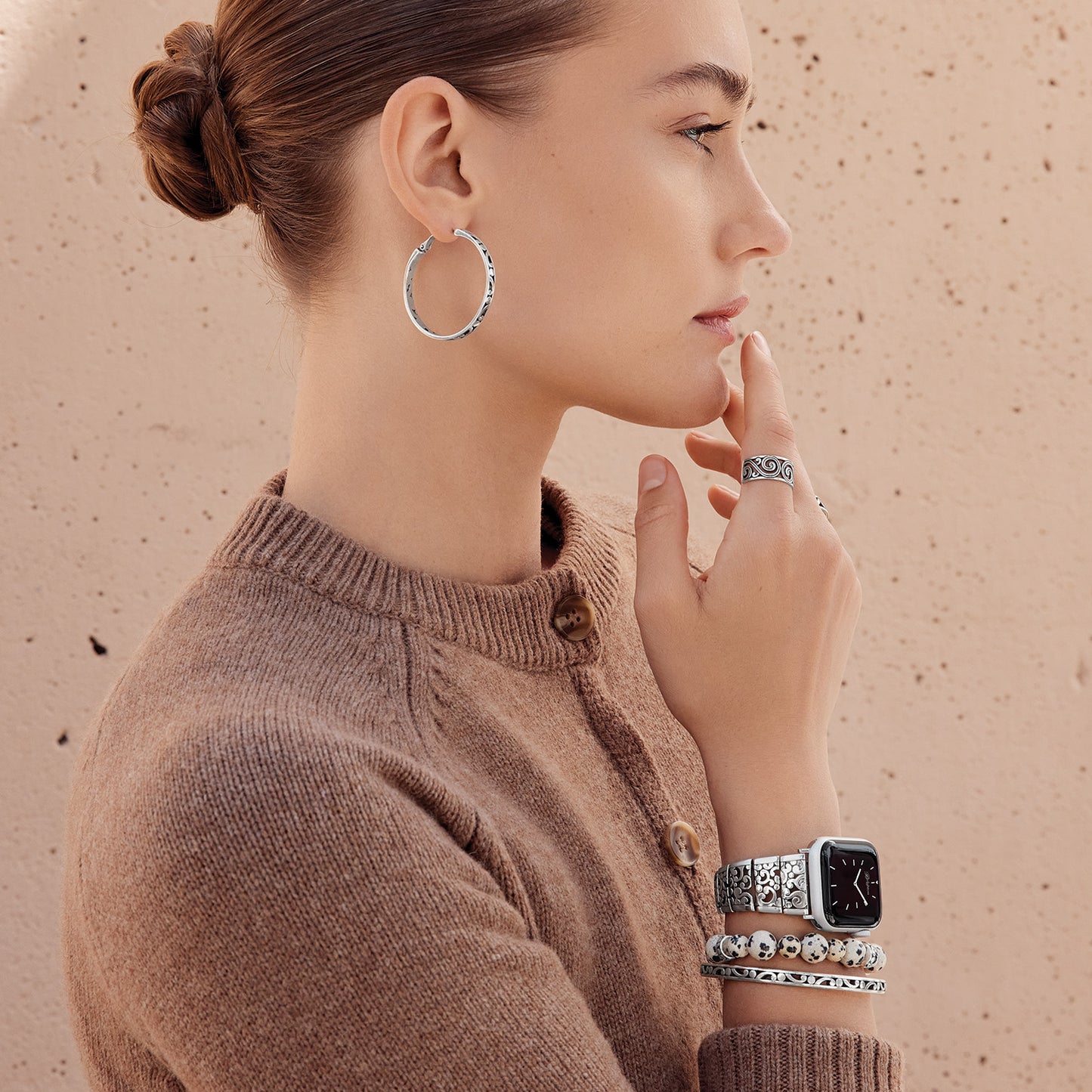 Model wearing Brighton silver-plated hoop earrings with coordinating Brighton accessories including a ring, watch, and bracelets.