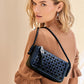 Model with a Brighton woven leather shoulder bag in navy and black with braided strap