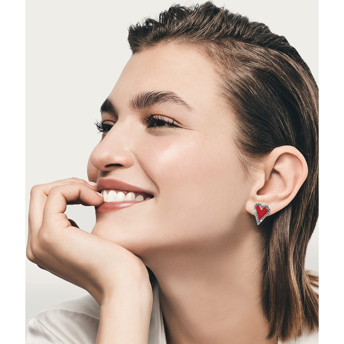 Model wearing a Brighton red enamel heart stud earring with silver-plated crystal-accented border trim