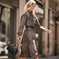 Model with a Brighton black handbag with embossed lettering and leather handles, styled with a leopard-print dress
