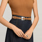 Model wearing a Brighton tan leather belt with silver-tone buckle and small medallion accents on the strap