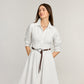 Model wearing a Brighton braided brown leather belt with silver-tone equestrian buckle over a white shirtdress