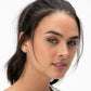 Model wearing a Brighton silver-plated elephant stud earring with scrollwork detail on the ear