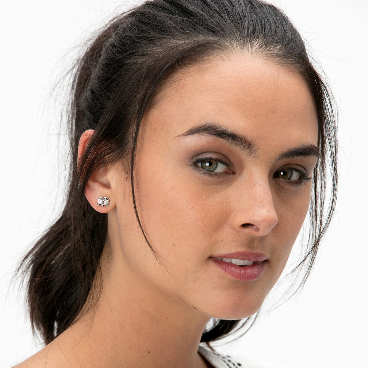 Model wearing a Brighton silver-plated elephant stud earring with scrollwork detail on the ear