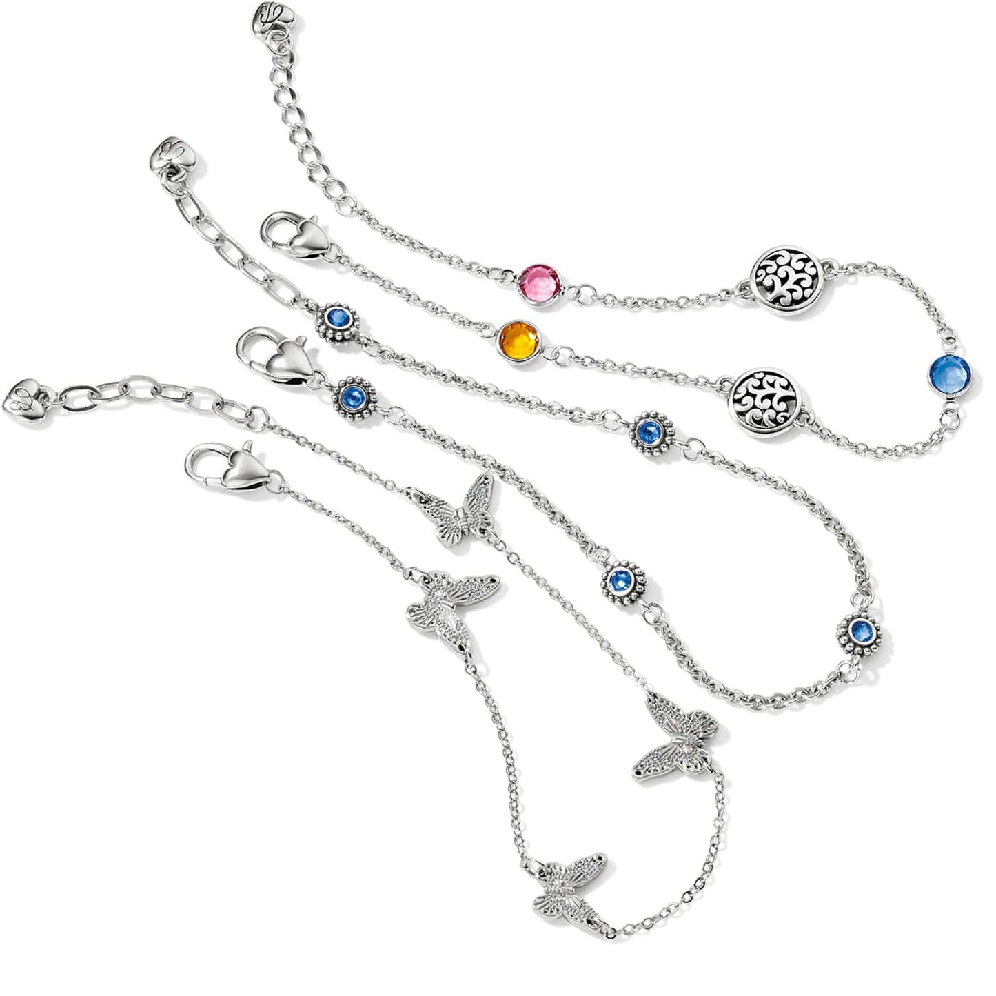 Brighton silver-plated bracelets with crystal stones, scroll medallions, and butterfly charms on a white background