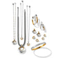 Brighton jewelry collection styled with two-tone necklaces, hoop earrings, stud earrings, and a hammered bangle bracelet