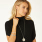 Model wearing a Brighton silver-plated pendant necklace with round medallion and coordinating Brighton accessories including bracelets and earrings