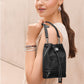 Model with a Brighton black leather bucket handbag with floral embossed detail and silver-tone hardware