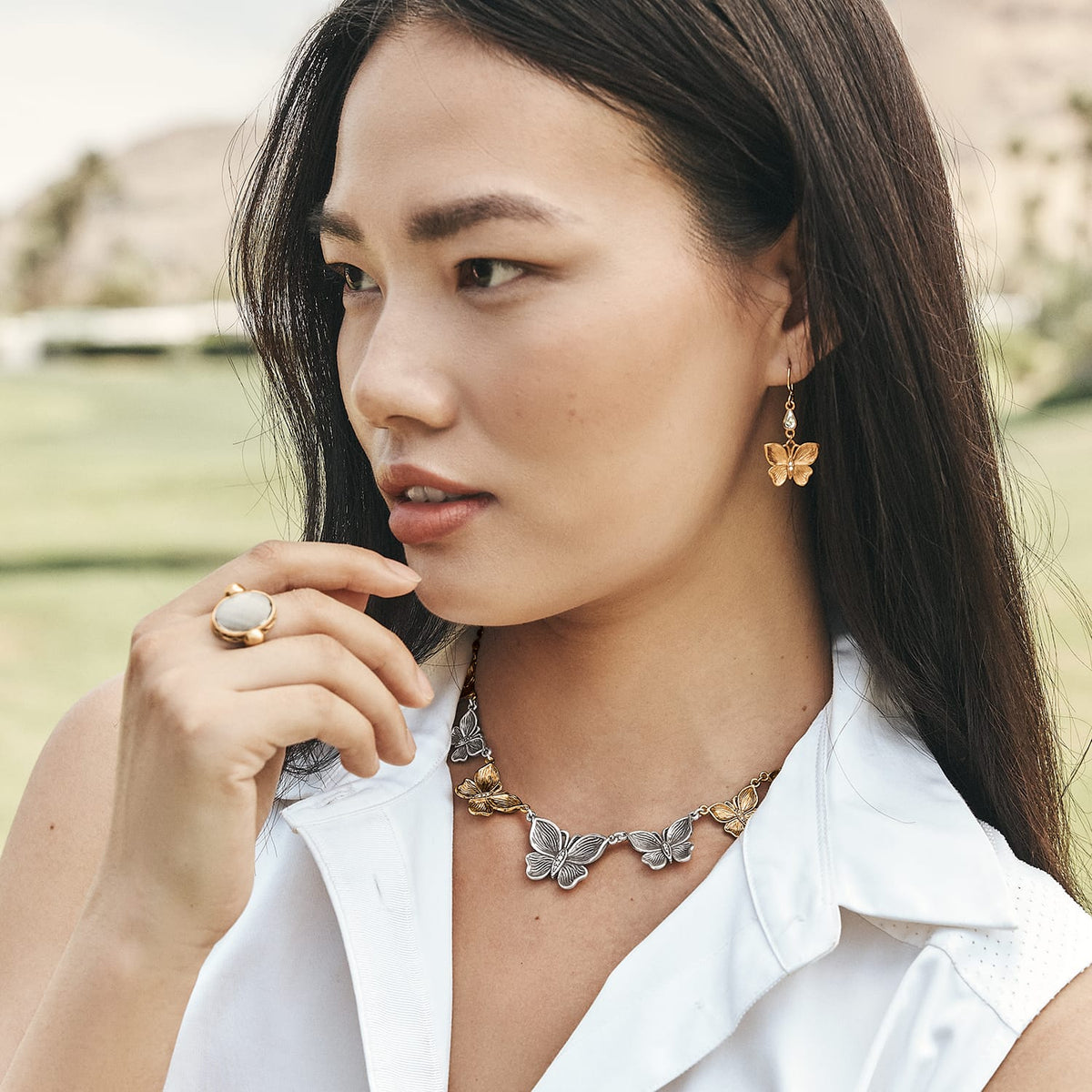 Model wearing a Brighton two-tone butterfly necklace with crystal accents and coordinating Brighton butterfly earrings and ring