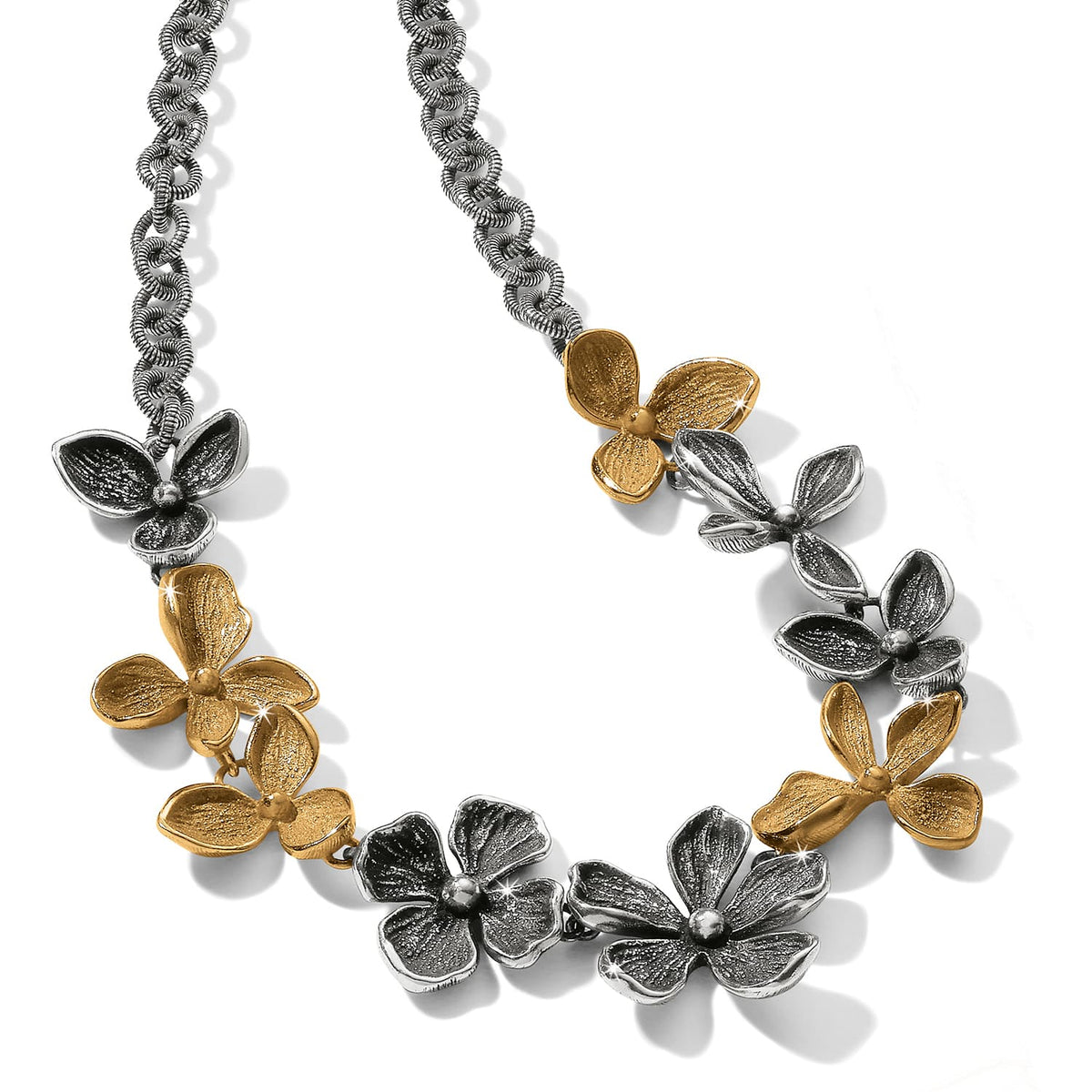 Brighton necklace with two-tone silver and gold flower charms on a textured chain on a white background