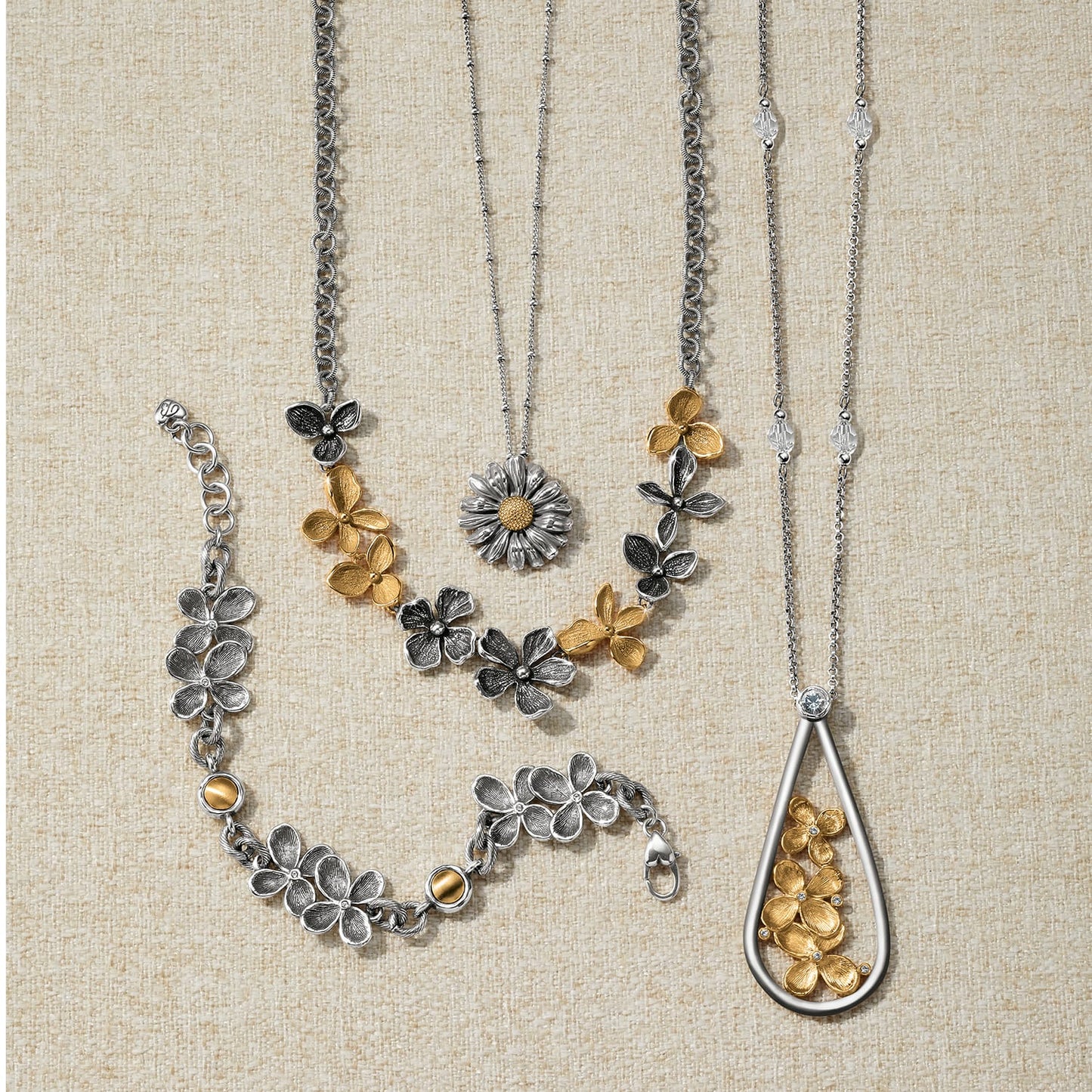 Brighton two-tone floral jewelry set styled with necklaces and bracelets featuring silver and gold flower motifs