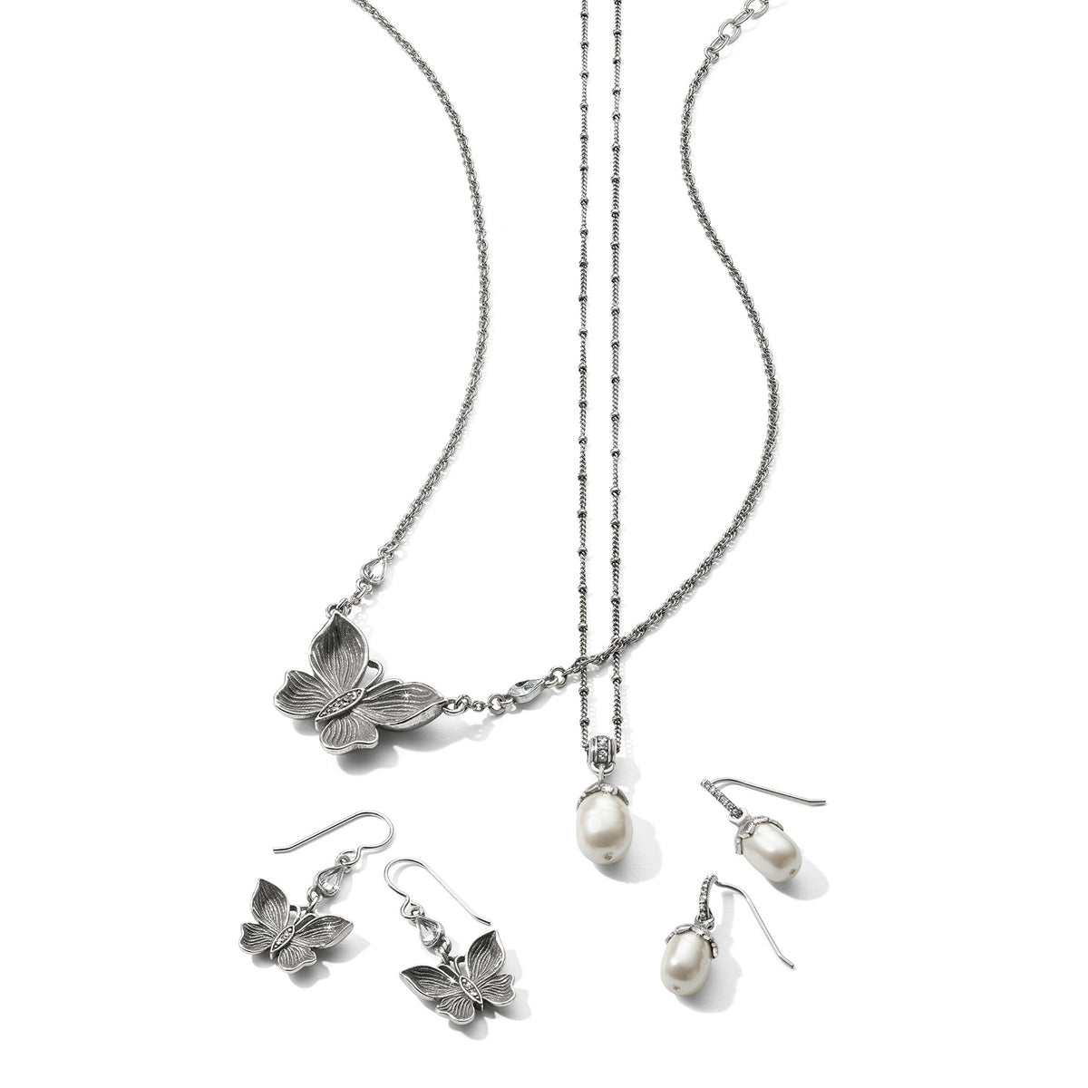 Brighton silver-plated butterfly necklace and earrings with rice pearl drop necklace and matching pearl earrings on a white background