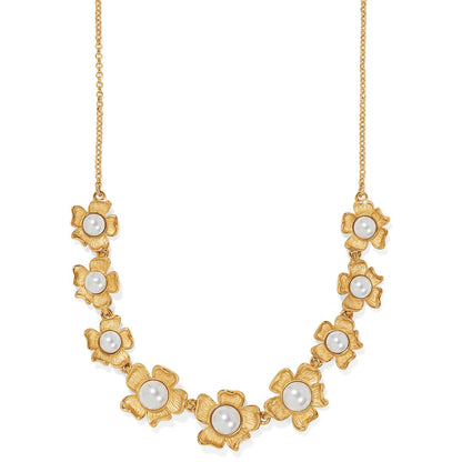 Brighton necklace with gold-plated flower stations centered with glass pearls on a delicate chain on a white background