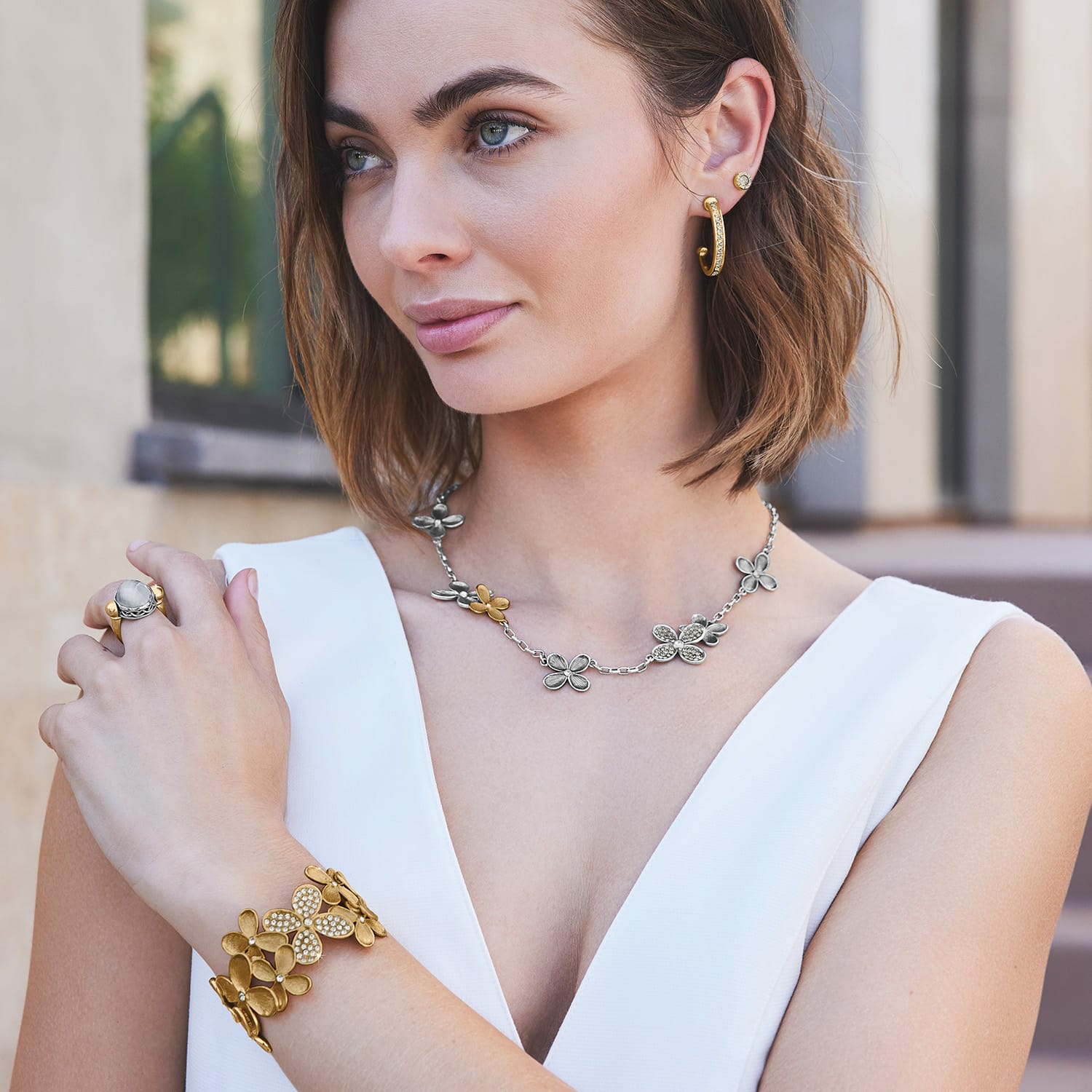 Model wearing a Brighton two-tone floral necklace with coordinating Brighton earrings, bracelet, and ring accessories