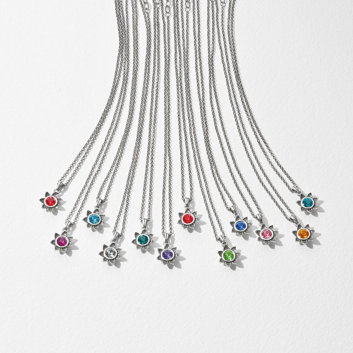 Brighton silver-plated flower pendant necklaces with assorted colored crystals arranged in a row on a white background