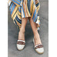 Model wearing Brighton white leather espadrille flats with woven brown leather knot detail and jute soles