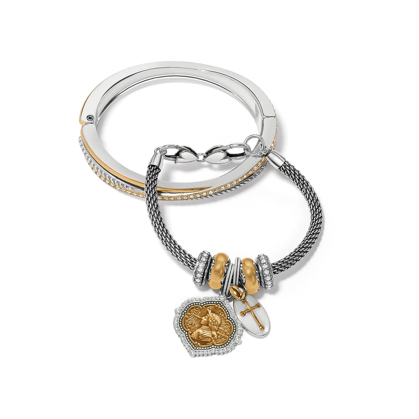 Brighton two-tone bangle and charm bracelet with crystal accents, cross charm, and medallion on a white background