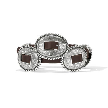 Brighton brown leather belt with oval silver-tone concho buckles featuring engraved floral and rope-edge detailing on a white background